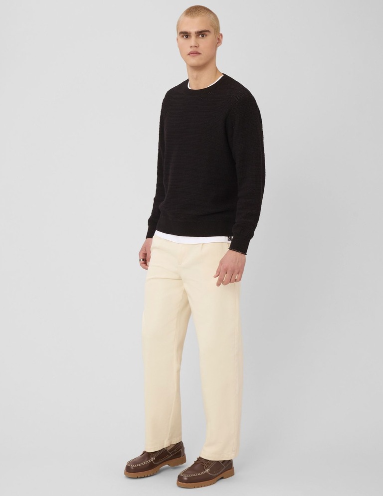 Homme en pantalon à pinces avec pull col rond et mocassins pour un style preppy élégant